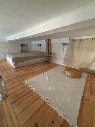 a room with a bed and a rug on a wooden floor at Appartement centre de Cassis in Cassis