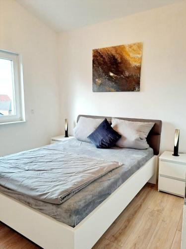 a bed in a white room with two night stands at Penthouse Vue Panoramique in Mechernich