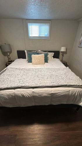 a large bed in a bedroom with two lamps at Value Rental no frills in Midvale
