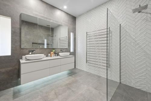 a bathroom with two sinks and a glass shower at Peninsula Farm Stay in Somerville