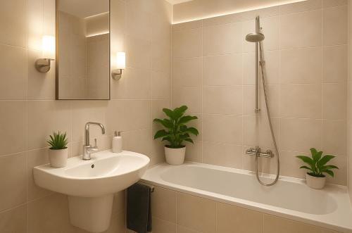 a bathroom with a sink and a bath tub with two plants at AltstadtNest Hannover in Hannover