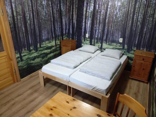 a bedroom with two beds in the woods at Viesumāja Kuncīši Murjāņos in Murjāņi