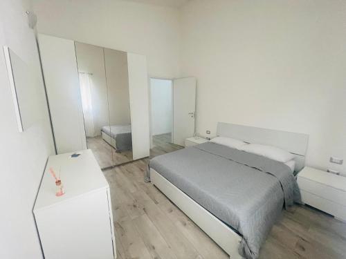 a white bedroom with a bed and a table at Il Mirto, Residenza Privata in Bacu Abis