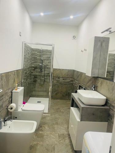 a bathroom with two sinks and a toilet and a shower at Il Mirto, Residenza Privata in Bacu Abis