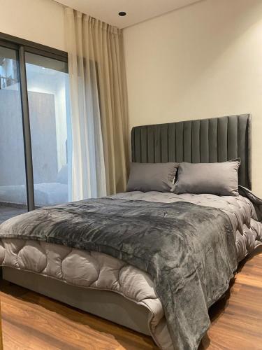 a bed in a bedroom with a large window at studio neuf calme et propre in Casablanca