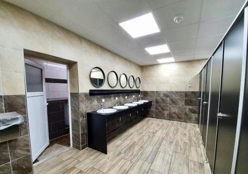 a bathroom with a row of sinks and mirrors at Feriensiedlung Schwalbennest - Bungalows in Dranske