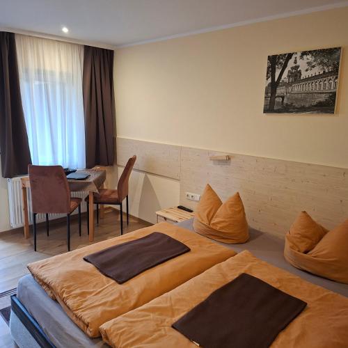 a hotel room with two beds and a table at Pension Lehmann in Radebeul