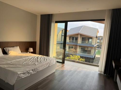a bedroom with a bed and a large window at HAHA'S Villa in Binh Hai