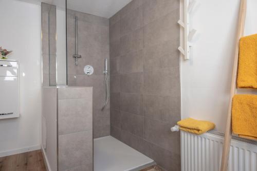 a shower with a glass door in a bathroom at Vacation, also with a dog, in Stade! in Stade
