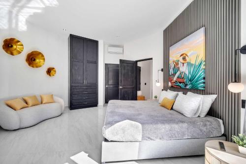 a bedroom with a large bed and a couch at Marbella Lane Coastal Elegance Villa with Pool in Cabo San Lucas