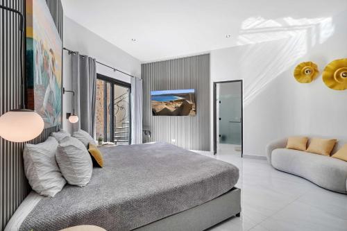 a bedroom with a large bed and a couch at Marbella Lane Coastal Elegance Villa with Pool in Cabo San Lucas