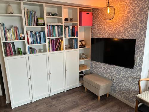 a living room with white cabinets and a flat screen tv at Charming holiday home on the harbour (5 persons) in Rødvig
