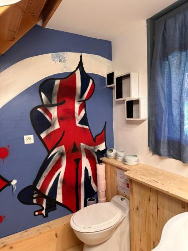 a bathroom with a toilet and a painting on the wall at Chambre Le mas d'Adelice in Taulignan