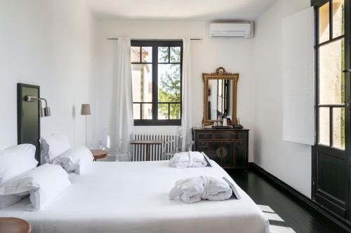 two beds in a white room with a mirror at Château Les Merles et ses Villas in Mouleydier