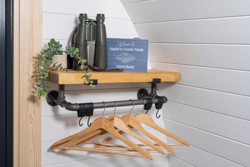 a wooden shelf hanging on a wall with bottles on it at Appin's Coorie Nook in Appin