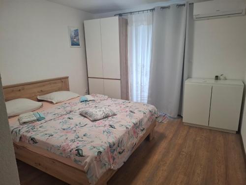 a small bedroom with a bed and a window at Apartman Skradin nono in Skradin