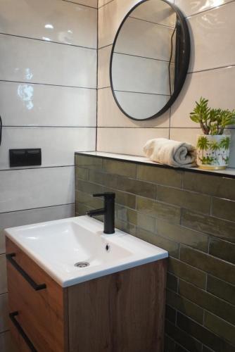 a bathroom with a sink and a mirror at Stodoła Pod Gwiazdami - Jezioro Głuszyńskie in Orle