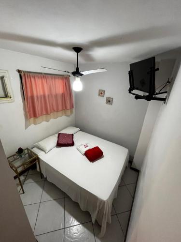 a bedroom with a bed with two red pillows on it at Pousada do Farol Bar e Restaurante in Vila Velha