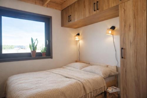 a bedroom with a bed with a window and two lights at Stodoła Pod Gwiazdami - Jezioro Głuszyńskie in Orle