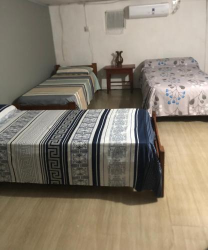 a room with two beds and a wooden floor at Iberá in Mercedes