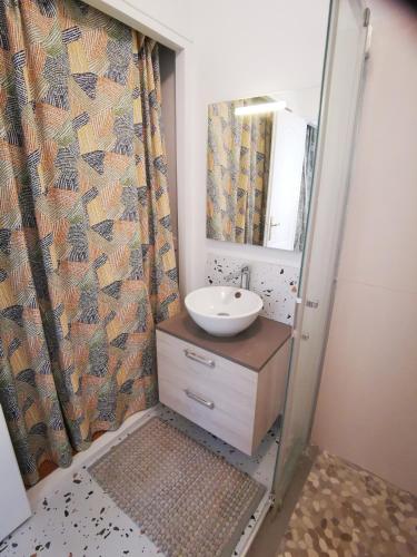 a bathroom with a sink and a mirror at Le Refuge du Vieux Moulin in Arles