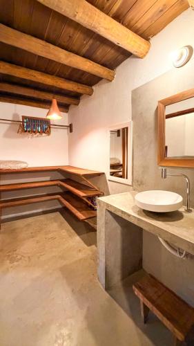 a bathroom with a sink and a counter with a mirror at Vila Alta Caraíva in Caraíva