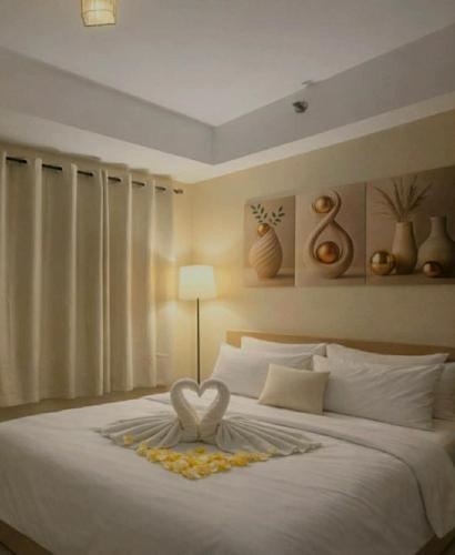 a bedroom with a white bed with a heart on it at MOA staycation Shore 1 tower D in Manila