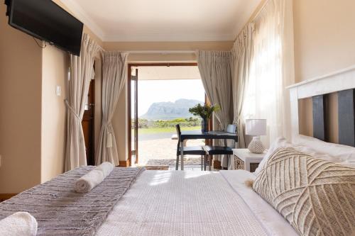 a bedroom with a bed and a view of the road at Coastline Serenity in Kleinmond