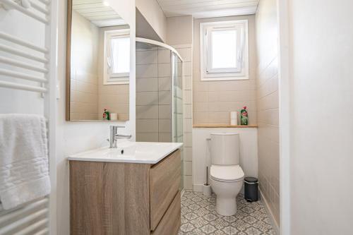 a bathroom with a toilet and a sink and a mirror at Maison Mylan, simple and practical! in Cholet