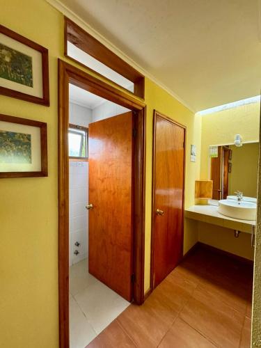 a bathroom with a wooden door and a sink at Olmue Natura Lodge & Spa in Olmué