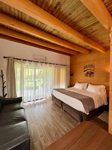 a bedroom with a large bed and a couch at Olmue Natura Lodge & Spa in Olmué
