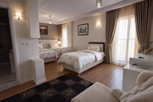 a hotel room with two beds and a couch at Kafaoğlu Otel in Ereğli
