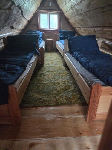 a room with three beds in a log cabin at Chata Między Górami in Zalesie