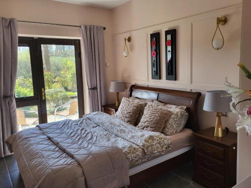 a bedroom with a bed and a large window at the ring of kerry riverside apartment in Killorglin