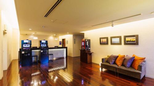 a living room with a couch and a kitchen at JR-East Hotel Mets Yokohama Tsurumi in Yokohama