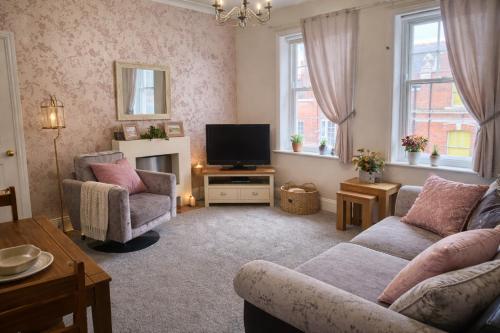 a living room with a couch and a tv at Clock Tower Flats Morpeth in Morpeth