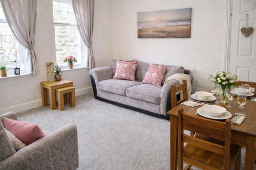 a living room with a couch and a table at Clock Tower Flats Morpeth in Morpeth