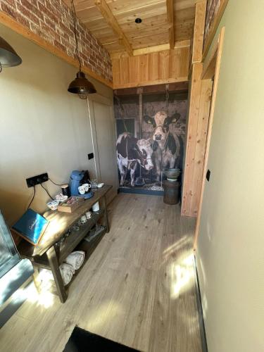 a room with a painting of a cow on the wall at B&B Opoes huusie in Lutten