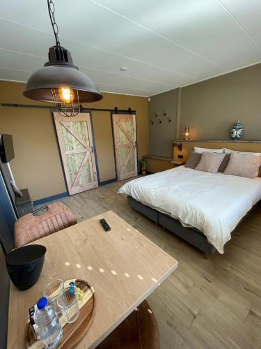 a bedroom with a large bed and a table at B&B Opoes huusie in Lutten
