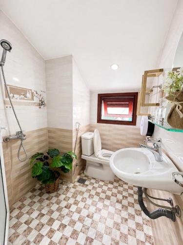 a bathroom with a toilet and a sink at Villa Thung Lũng Hồng 2 in Ấp Kim Thạch