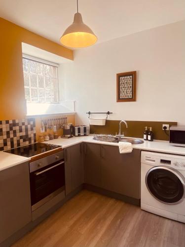 a kitchen with a sink and a washing machine at Brylach Steading in Aberlour