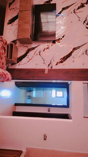 a kitchen with a window and a marble wall at Taj Plaza in Sowayma