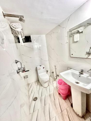 a white bathroom with a sink and a toilet at The Kandarp Villa in Jaipur