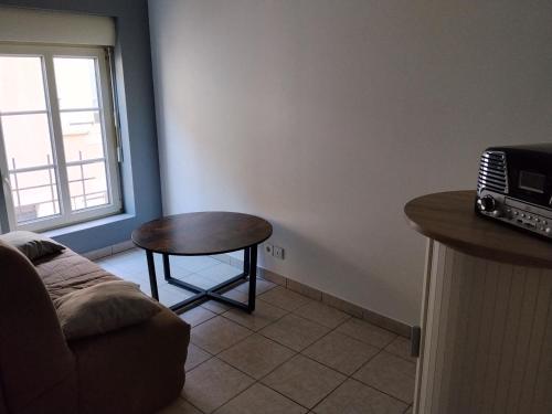 a living room with a table and a couch at Yapas in Beaumont-sur-Sarthe