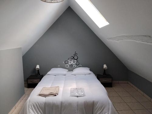 a bedroom with a large bed with white sheets at Yapas in Beaumont-sur-Sarthe