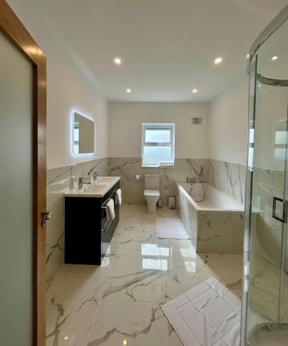a bathroom with a tub and a toilet and a sink at Modern house Boyle in Boyle