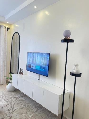 a living room with a tv on a white wall at SerenityLoft by Gloria in Thika