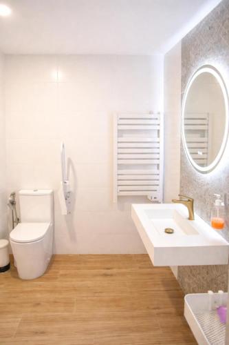 a bathroom with a sink and a toilet and a mirror at Apartamento Aljibe in Arcos de la Frontera