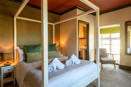 a bedroom with a canopy bed with towels on it at The Crown Hotel in Lynton