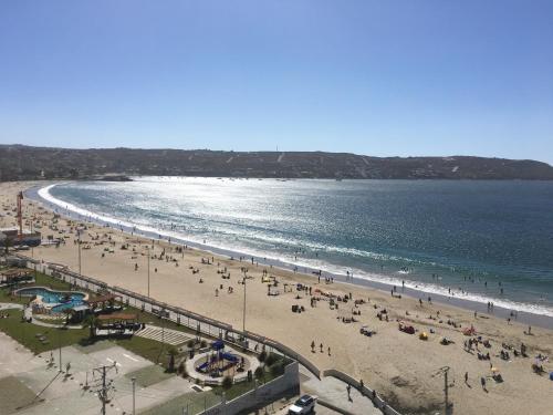 a group of people on a beach with the ocean at Departamento Playa Herradura in Coquimbo